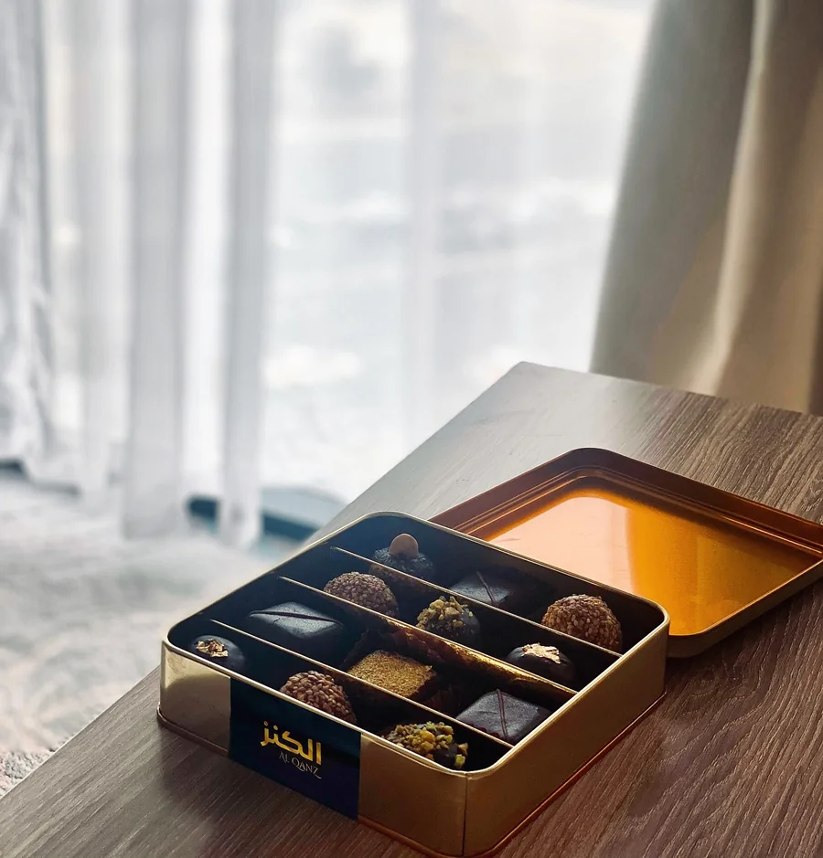 Al Qanz gold gift tin of chocolates by a window